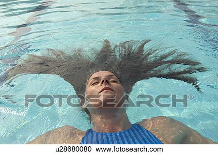 Woman with long hair floating in swimming pool, eyes closed View Large Photo Image Stock Image - Woman with long hair floating in swimming pool, eyes closed. Fotosearch