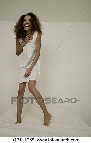 Woman jumping on bed View Large Photo Image Stock Photo - Woman jumping on bed. Fotosearch