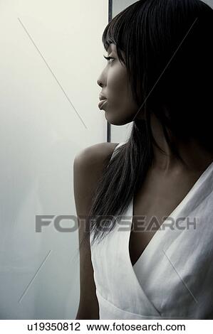 Stock Image - Woman next to a window. Fotosearch