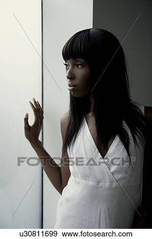 Woman next to a window View Large Photo Image Stock Photo - Woman next to a window. Fotosearch