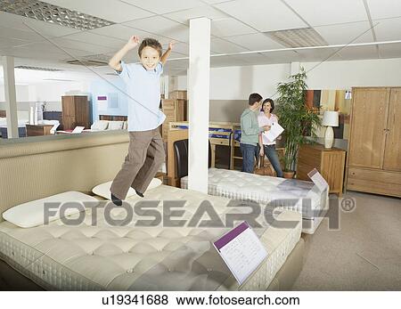Boy jumping on bed in furniture store. View Large Photo Image Stock Photo - Boy jumping on bed in furniture store.. Fotosearch
