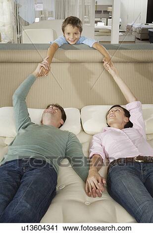 Couple lying on bed in a shop with son. View Large Photo Image Stock Image - Couple lying on bed in a shop with son.. Fotosearch