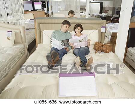 Family looking at brochures on a bed. View Large Photo Image Stock Photograph - Family looking at brochures on a bed.. Fotosearch