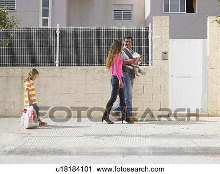 Family walking on pavement - father with baby (5 months) in sling, young daughter (4-6) with shopping dragging behind, Alicante, Spain, View Large Photo Image Stock Image - Family walking on pavement - father with baby (5 months) in sling, young daughter (4-6) with shopping dragging behind, Alicante, Spain,. Fotosearch