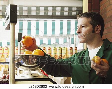 Greengrocer weighing oranges. View Large Photo Image Stock Image - Greengrocer weighing oranges.. Fotosearch