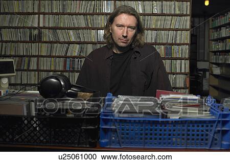 Mature man behind counter in music shop, portrait View Large Photo Image Stock Image - Mature man behind counter in music shop, portrait. Fotosearch