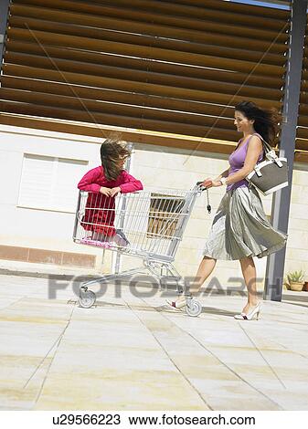 Mother pushing daughter (5-7) in supermarket trolley, Alicante, Spain, View Large Photo Image Stock Image - Mother pushing daughter (5-7) in supermarket trolley, Alicante, Spain,. Fotosearch