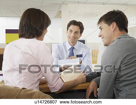 Salesman talking to couple in a shop. View Large Photo Image Stock Photo - Salesman talking to couple in a shop.. Fotosearch