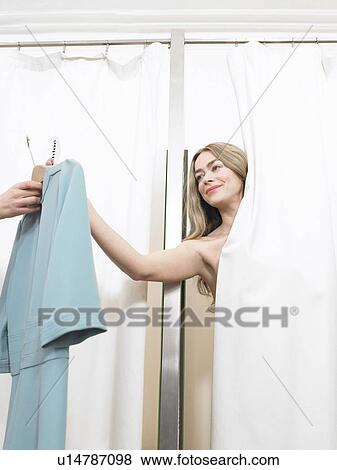 Woman in changing room checking price tag on garment View Large Photo Image Stock Photo - Woman in changing room checking price tag on garment. Fotosearch