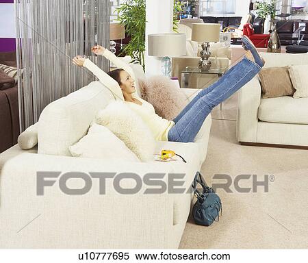 Woman jumping on sofa in furniture store. View Large Photo Image Stock Photography - Woman jumping on sofa in furniture store.. Fotosearch