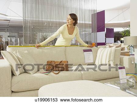 Woman measuring sofa in furniture store. View Large Photo Image Stock Image - Woman measuring sofa in furniture store.. Fotosearch