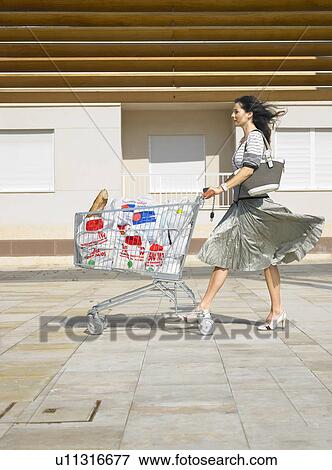 Woman pushing supermarket trolley against wind, Alicante, Spain, View Large Photo Image Stock Photo - Woman pushing supermarket trolley against wind, Alicante, Spain,. Fotosearch