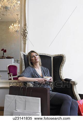 Young woman relaxing in restaurant surrounded by shopping bags View Large Photo Image Stock Photography - Young woman relaxing in restaurant surrounded by shopping bags. Fotosearch