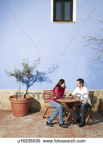 Couple sitting on garden terrace drinking wine View Large Photo Image Stock Photography - Couple sitting on garden terrace drinking wine. Fotosearch