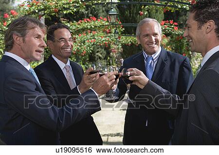 Four businessmen drinking wine in a garden View Large Photo Image Stock Photograph - Four businessmen drinking wine in a garden. Fotosearch