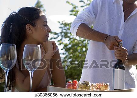 Stock Photograph - man opening a bottle of wine. Fotosearch