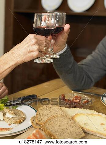Senior couple toasting each other with wine, close-up View Large Photo Image Stock Photo - Senior couple toasting each other with wine, close-up. Fotosearch