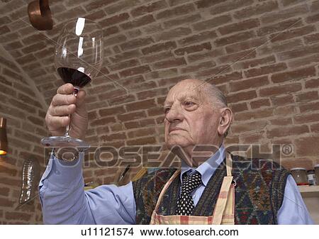 Senior man looking at wine in glass View Large Photo Image Picture - Senior man looking at wine in glass. Fotosearch