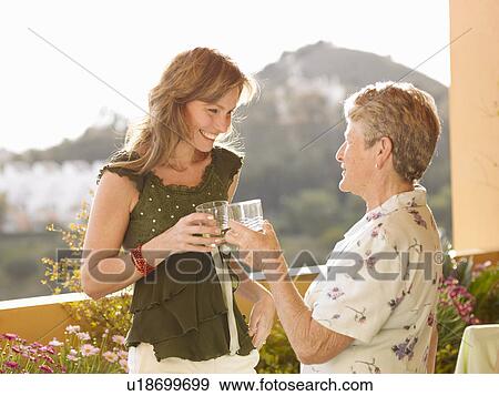 Senior woman and adult daughter making celebratory toast on balcony View Large Photo Image Stock Photo - Senior woman and adult daughter making celebratory toast on balcony. Fotosearch