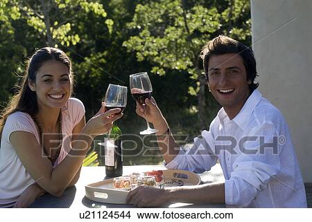 Young couple enjoying wine and appetizers View Large Photo Image Picture - Young couple enjoying wine and appetizers. Fotosearch