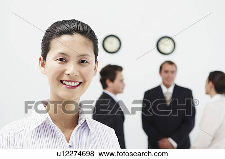 Stock Photo - Portrait of woman, people behind. Fotosearch