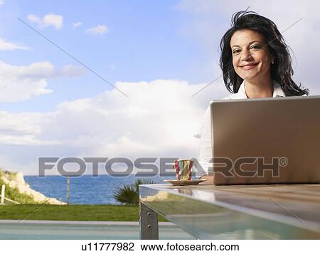 Woman on laptop out doors on decking View Large Photo Image Stock Image - Woman on laptop out doors on decking. Fotosearch