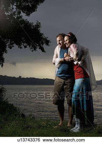 Man and woman standing in the rain View Large Photo Image Stock Photograph - Man and woman standing in the rain. Fotosearch