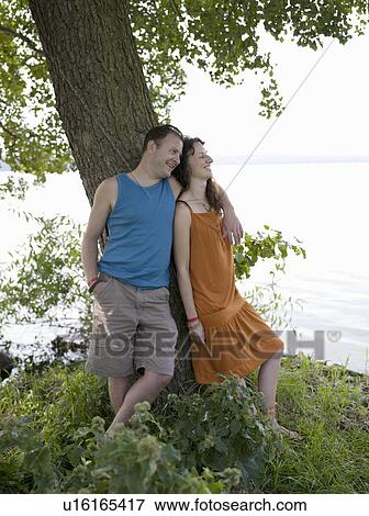 Man and woman standing under tree View Large Photo Image Stock Photo - Man and woman standing under tree. Fotosearch