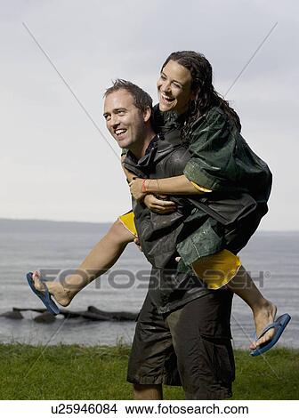 Man carrying woman on his back View Large Photo Image Picture - Man carrying woman on his back. Fotosearch