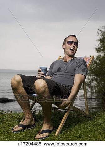 Man sitting in garden chair in the rain View Large Photo Image Stock Photograph - Man sitting in garden chair in the rain. Fotosearch