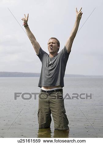 Stock Photo - Man standing in shallow water . Fotosearch
