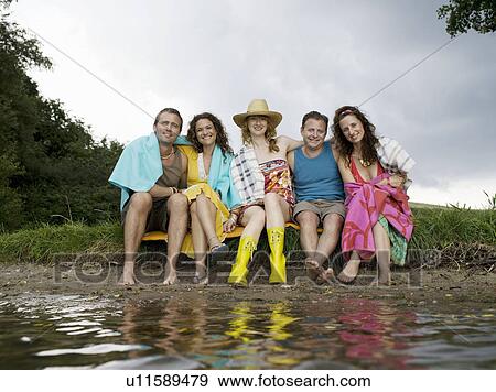People sitting together by waterfront View Large Photo Image Stock Photo - People sitting together by waterfront. Fotosearch