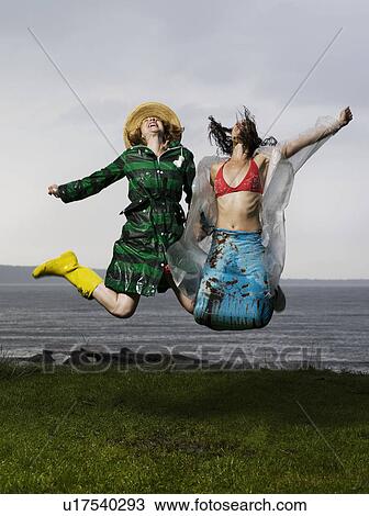 Two women jumping together View Large Photo Image Stock Image - Two women jumping together. Fotosearch