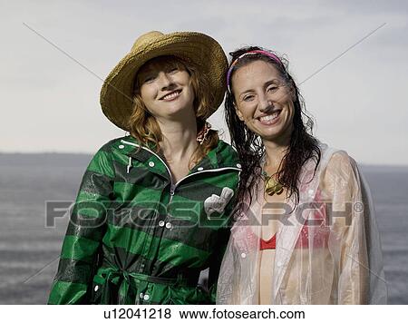 Two women looking into camera smiling View Large Photo Image Stock Photo - Two women looking into camera smiling. Fotosearch