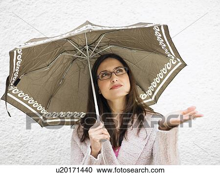 Woman holding umbrella, holding out hand View Large Photo Image Stock Image - Woman holding umbrella, holding out hand. Fotosearch