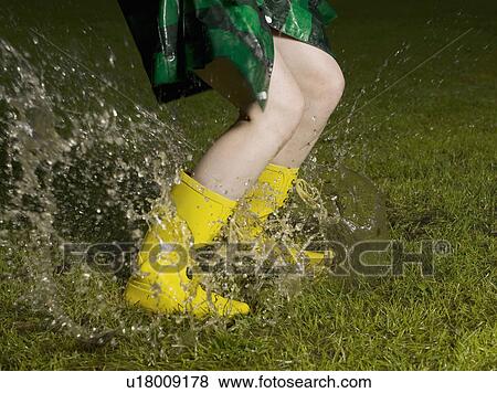 Woman jumping in rain puddle View Large Photo Image Stock Photo - Woman jumping in rain puddle. Fotosearch