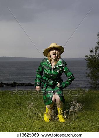 Stock Photo - Woman jumping in water puddle . Fotosearch
