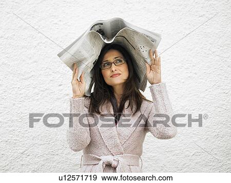 Woman outdoors, covering head with newspaper View Large Photo Image Stock Photo - Woman outdoors, covering head with newspaper. Fotosearch