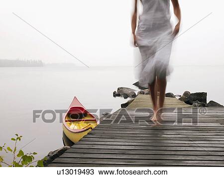 Woman walking on a dock near a boat. View Large Photo Image Stock Image - Woman walking on a dock near a boat.. Fotosearch