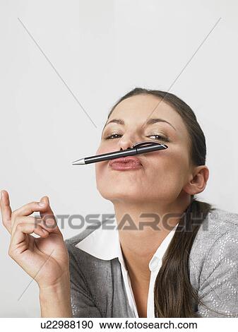 Businesswoman playing with pen pretending it's a moustace View Large Photo Image Stock Image - Businesswoman playing with pen pretending it's a moustace. Fotosearch
