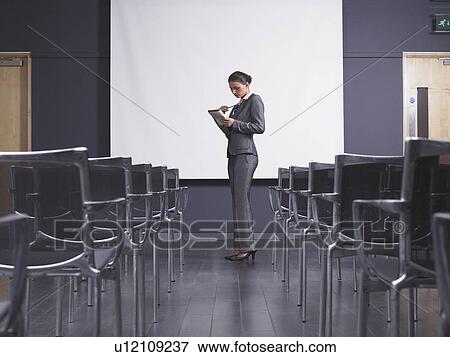 Woman practicing speech in empty presentation room View Large Photo Image Stock Photo - Woman practicing speech in empty presentation room. Fotosearch