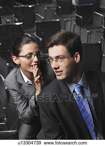 Woman whispering to man sitting in auditorium View Large Photo Image Stock Photo - Woman whispering to man sitting in auditorium. Fotosearch