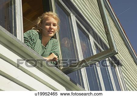 Young woman appearing from window. View Large Photo Image Stock Photography - Young woman appearing from window.. Fotosearch