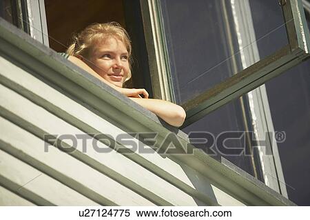 Stock Photography - Young woman appearing from window.. Fotosearch