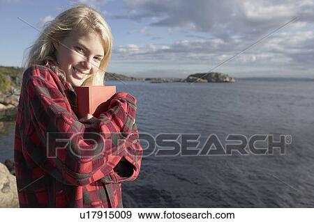 Young Woman By sea cuddling book. View Large Photo Image Stock Photo - Young Woman By sea cuddling book.. Fotosearch