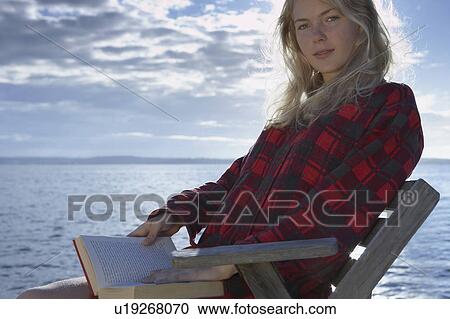 Young Woman by sea reading book. View Large Photo Image Stock Image - Young Woman by sea reading book.. Fotosearch
