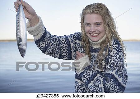 Stock Photography - Young Woman having caught fish.. Fotosearch