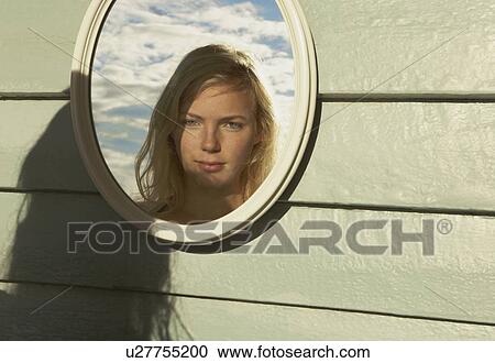 Stock Image - Young Woman Looking in Mirror outside.. Fotosearch