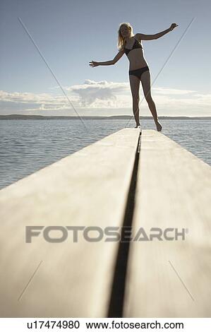 Stock Image - Young woman on diving board.. Fotosearch