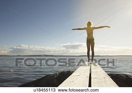 Stock Image - Young woman on diving board.. Fotosearch